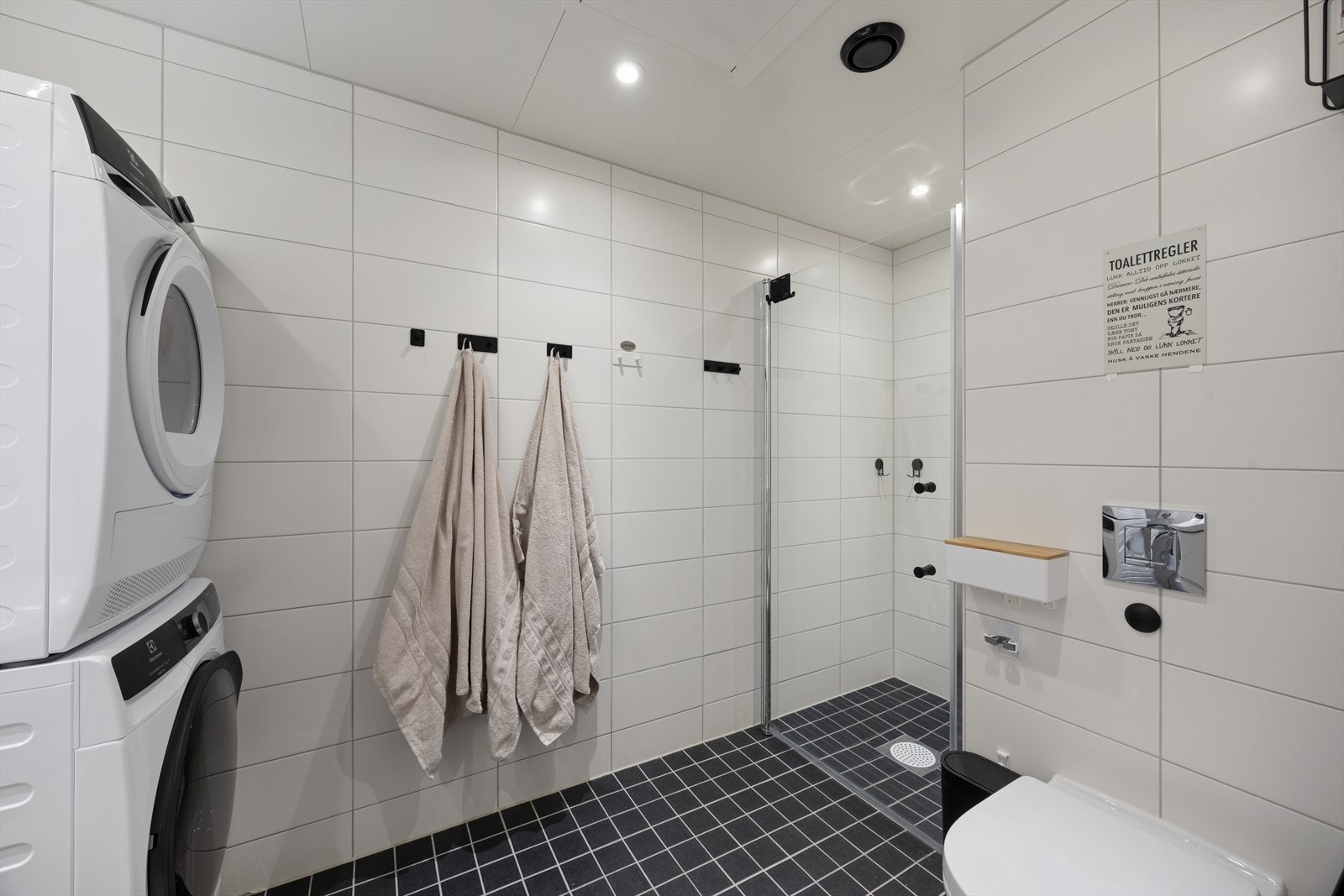 Badet er utstyrt med baderomsinnredning, speil, dusjhjørne, vegghengt toalett og opplegg for vaskemaskin og tørketrommel. Galleribilde