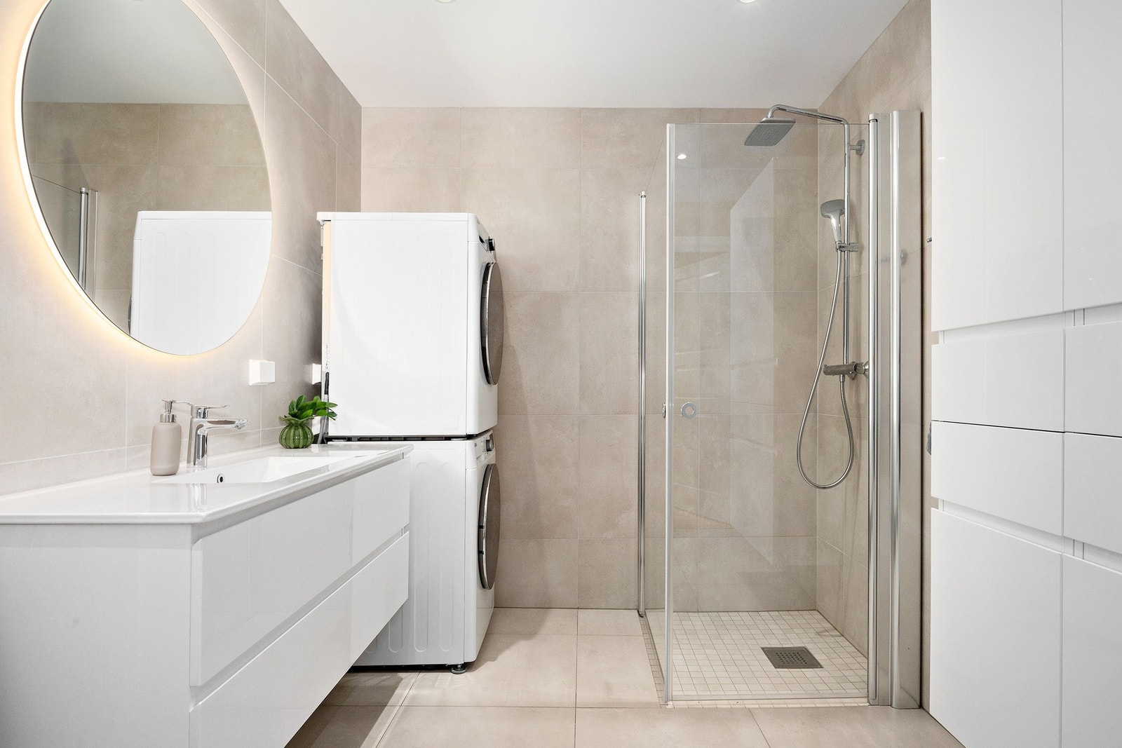 Her finner du elektriske varmekabler i gulv, moderne innredning og opplegg for vaskemaskin og tøretrommel. Galleribilde