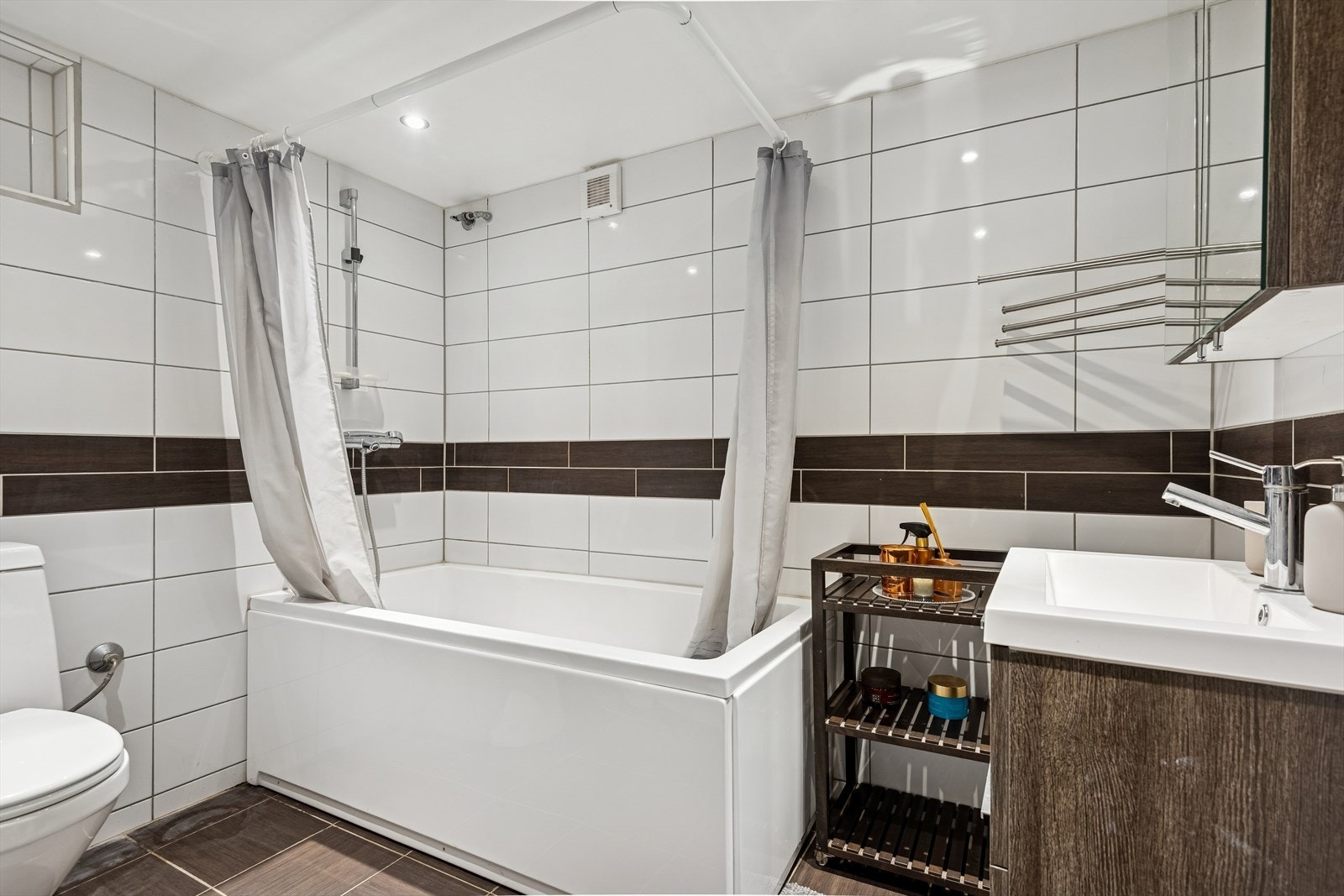 Badet i underetasjen er flislagt og utstyrt med badekar. Galleribilde