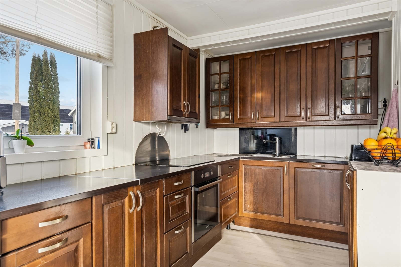 Kjøkkeninnredning i tre med rikelig skap- og benkeplass. Galleribilde