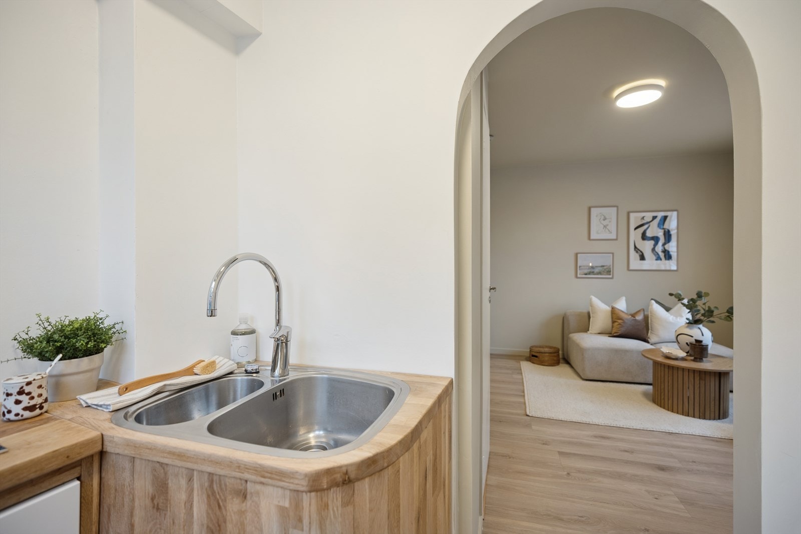 Kjøkken med åpen sikt inn mot stuen gjennom buet åpning. Galleribilde