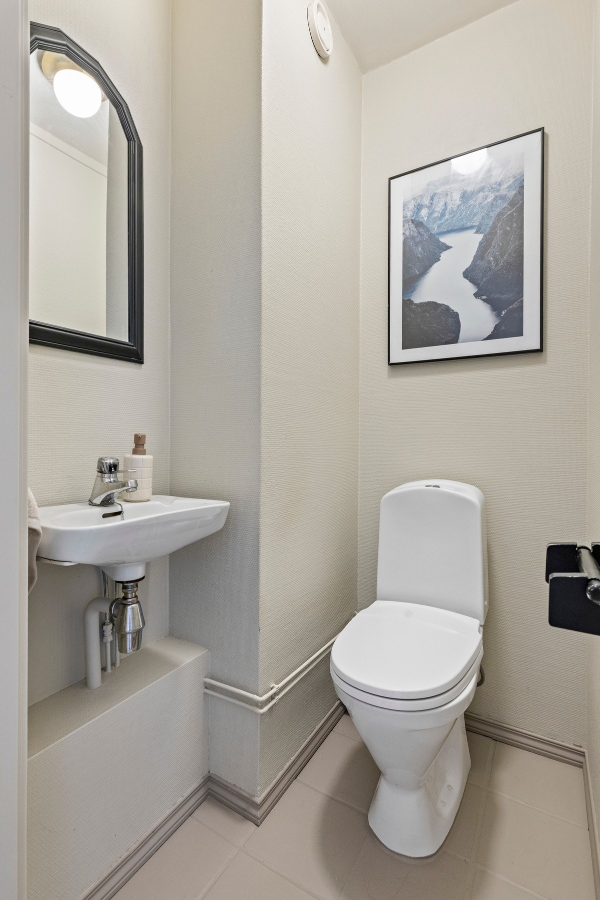 Toalettrommet er utstyrt med et gulvstående toalett og en servant i porselen Galleribilde