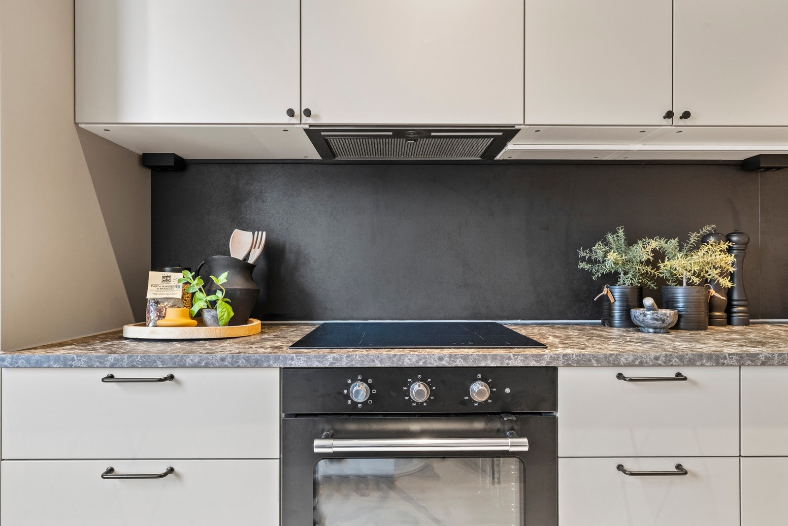 Rommet er utstyrt med integrerte hvitevarer som platetopp, komfyr og oppvaskmaskin Galleribilde