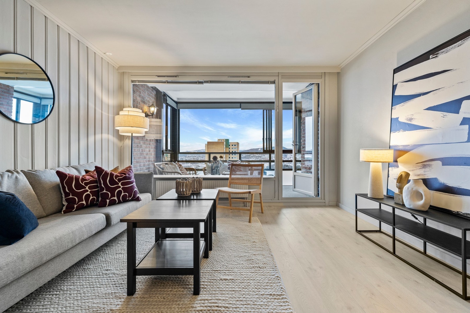 Stuen har store vinduer som sørger for naturlig lysinnslipp gjennom dagen Galleribilde