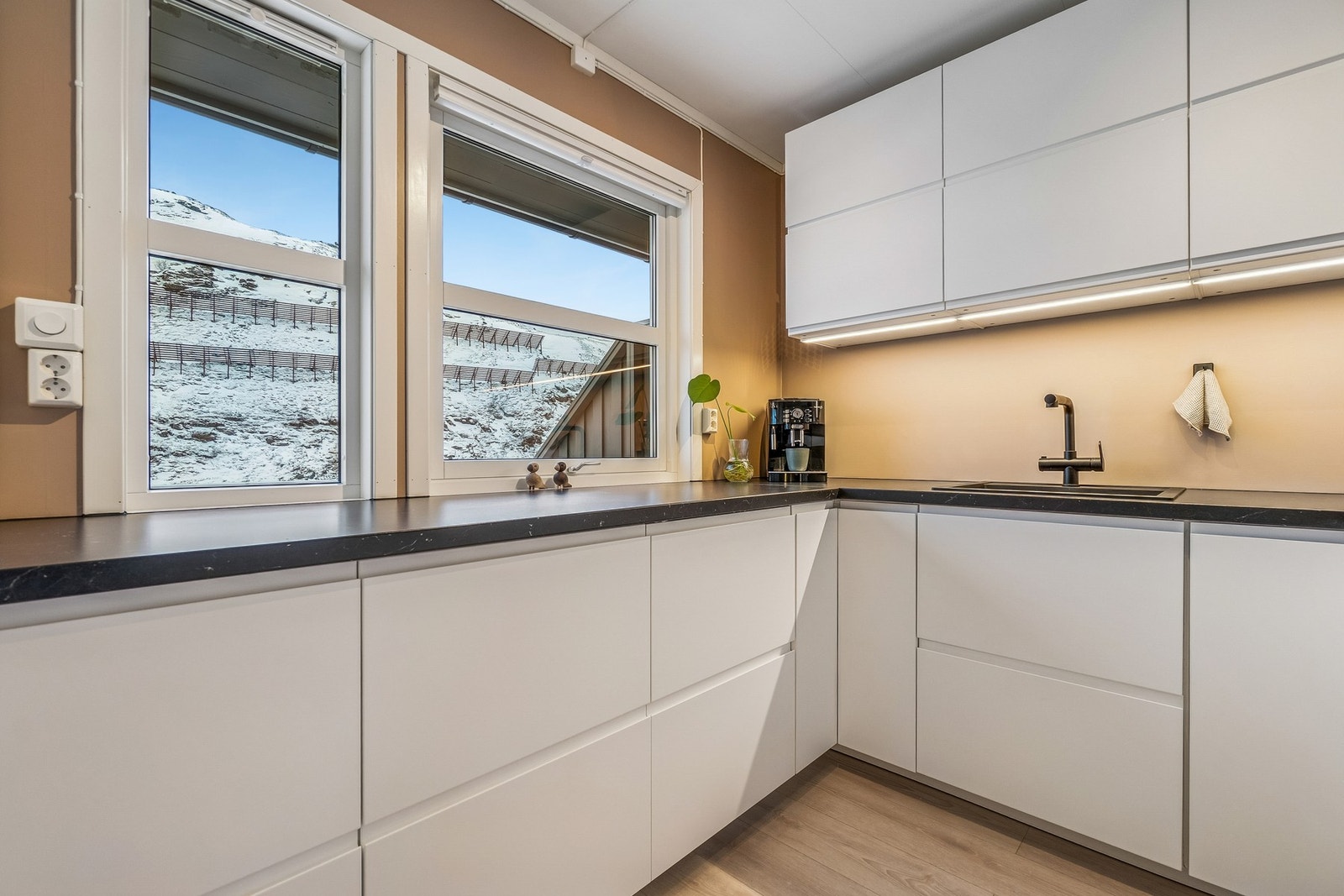 Et stort vindu på kjøkkenet gjør at rommet føles luftig og gir naturlig lysinnslipp. Det er integrerte hvitevarer som medfølger handelen. Galleribilde