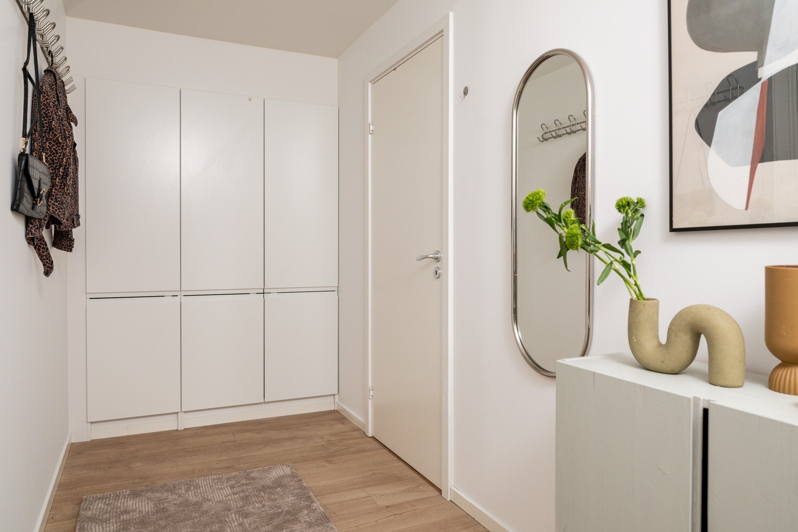 Entréen har enstavs laminat på gulv, deilig gulvvarme, glatte lysmalte overflater og skjult elektrisk anlegg. Det er god oppbevaringsplass i innebygde garderobeskap som medfølger i handelen, samt ytterligere plass til oppheng, skoskap eller kommoder. Galleribilde