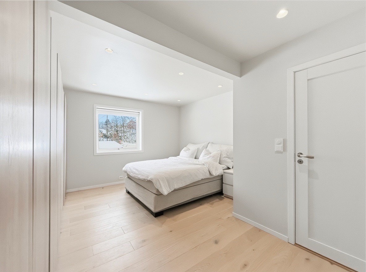 Hovedsoverom i hovedetasjen med dobbeltseng og store vinduer Galleribilde