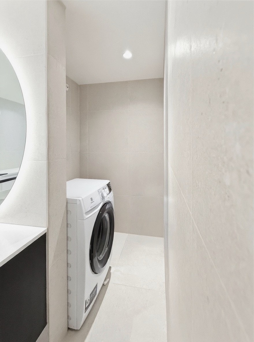Praktisk vaskesone med vaskemaskin og tørketrommel i baderommet Galleribilde