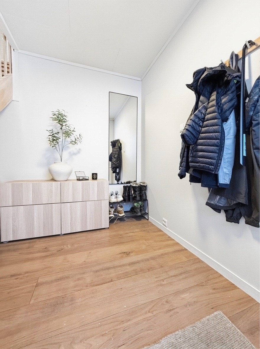 Hall med sittebenk, knagger og direkte adkomst til trapp som fører til stue og kjøkken Galleribilde