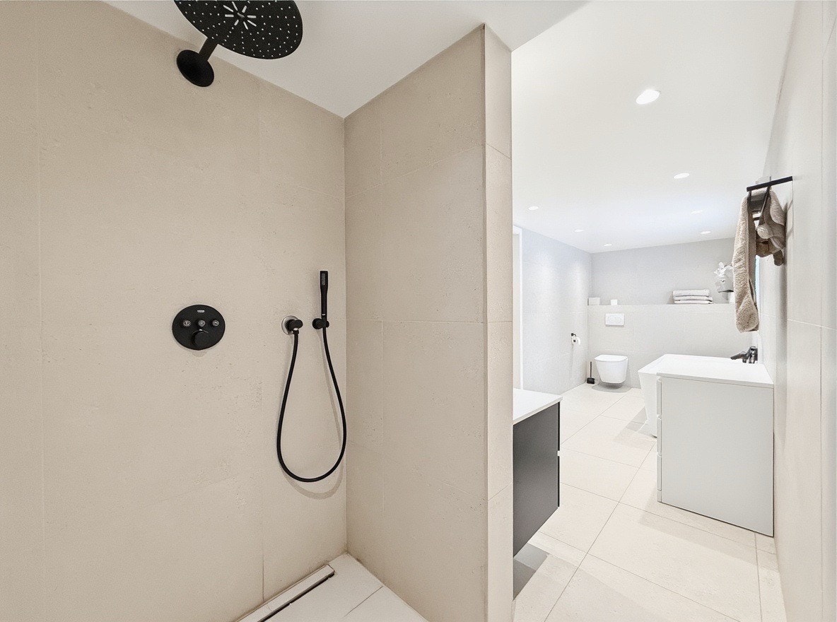 Badet har vegghengt toalett og elegante armaturer Galleribilde