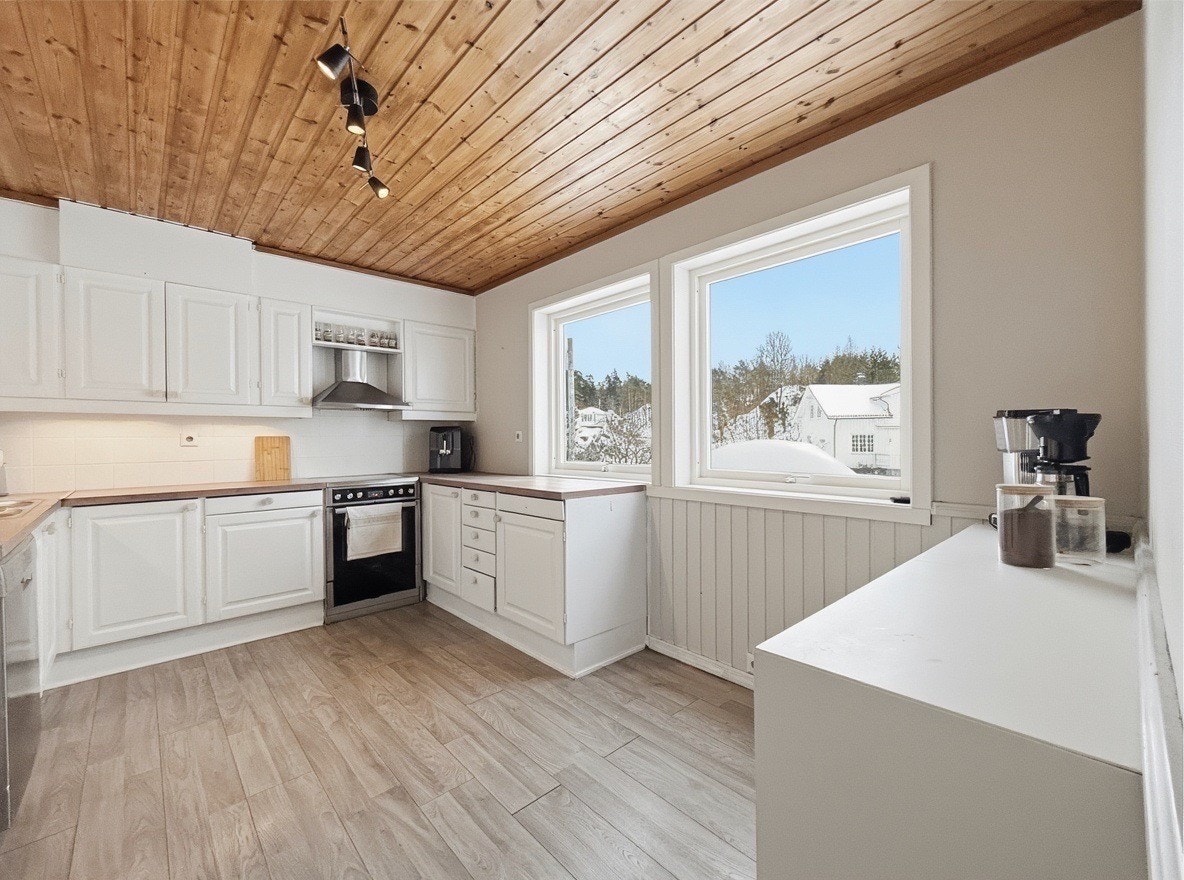 Ekstra kjøkkeninnredning gir rikelig lagringsplass og naturlig lys Galleribilde