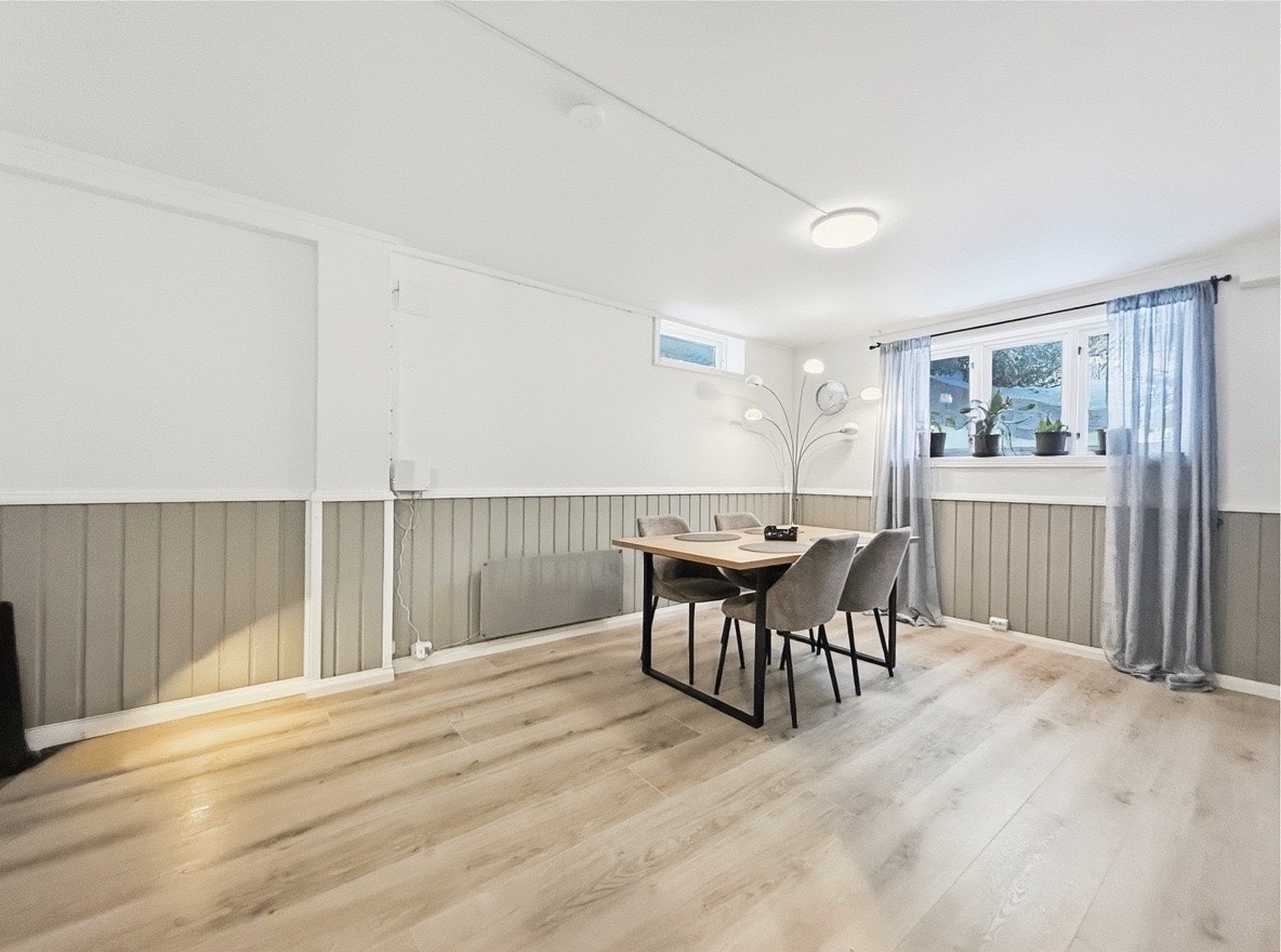 Romslig oppholdsrom med spiseplass og stue i åpen løsning Galleribilde