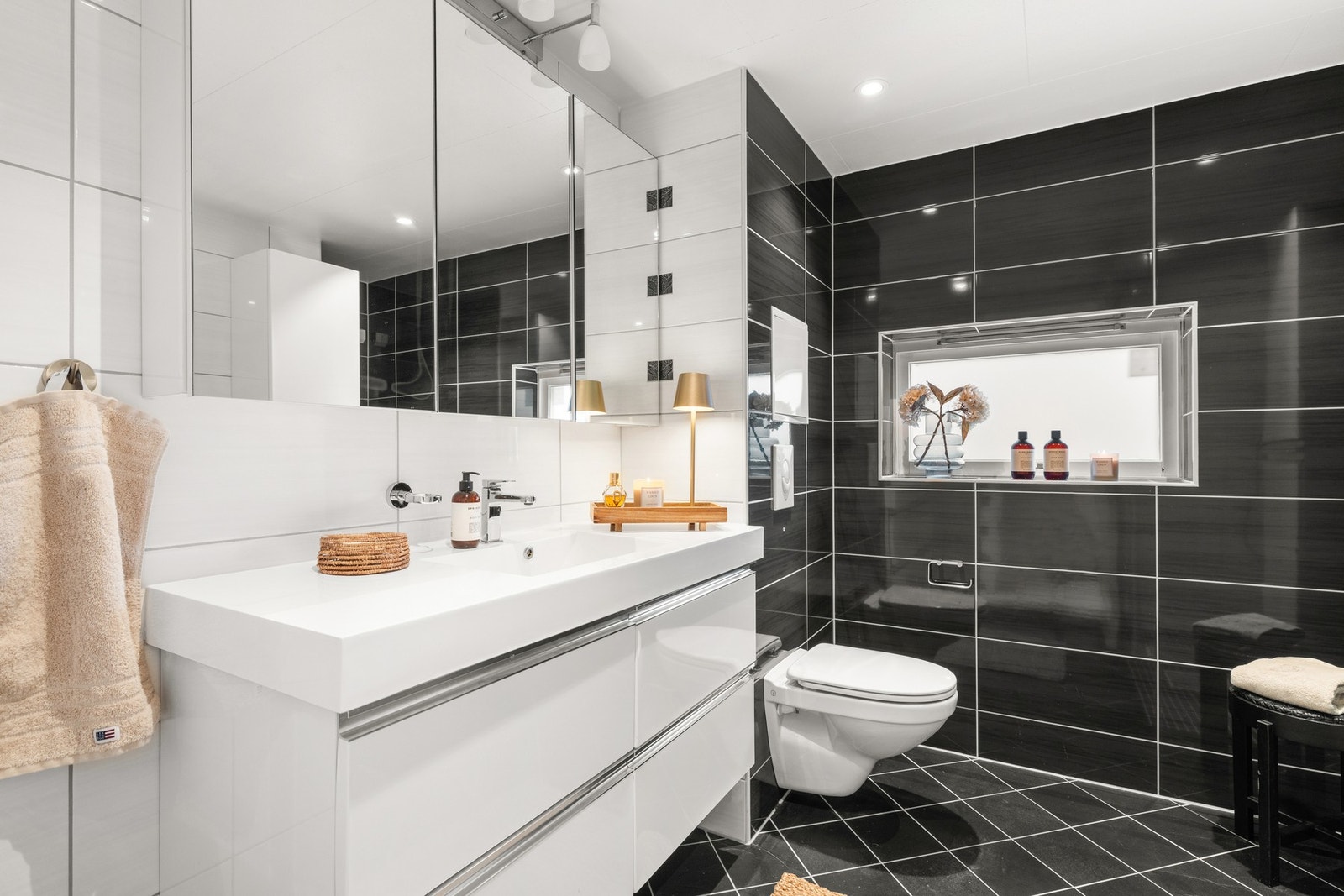 Moderne baderom med vegghengt toalett og servantinnredning med speilskap Galleribilde