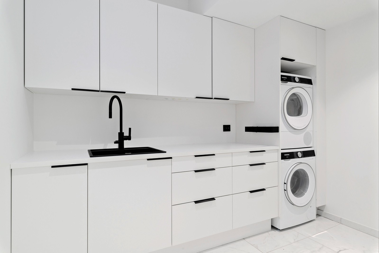 Vaskerommet liger i 1. etasje og har en fin innredning med over- og underskap, vask og nisje for både vaskemaskin og tørketromel. Galleribilde