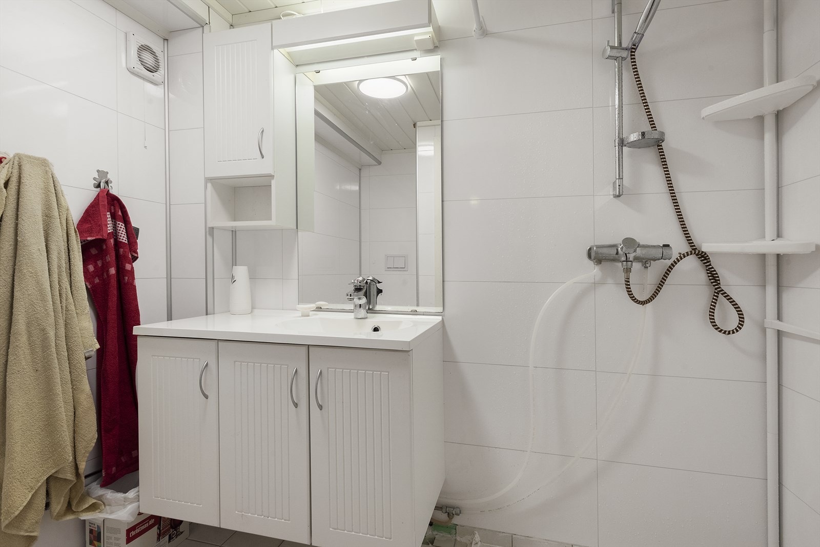 Bad i kjeller innredet med dusjnisje, baderomsinnredning med servant og toalett. Galleribilde