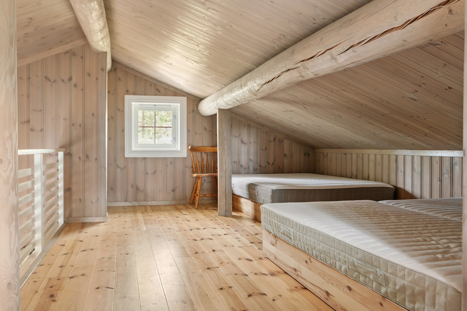 Her oppe er det god plass til flere sengeplasser, med en åpen løsning mot stuen under. Galleribilde