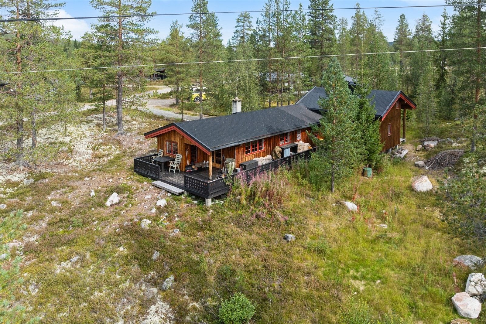 Hytta ligger usjenert til i et etablert hytteområde, omkranset av fjellnatur. Galleribilde