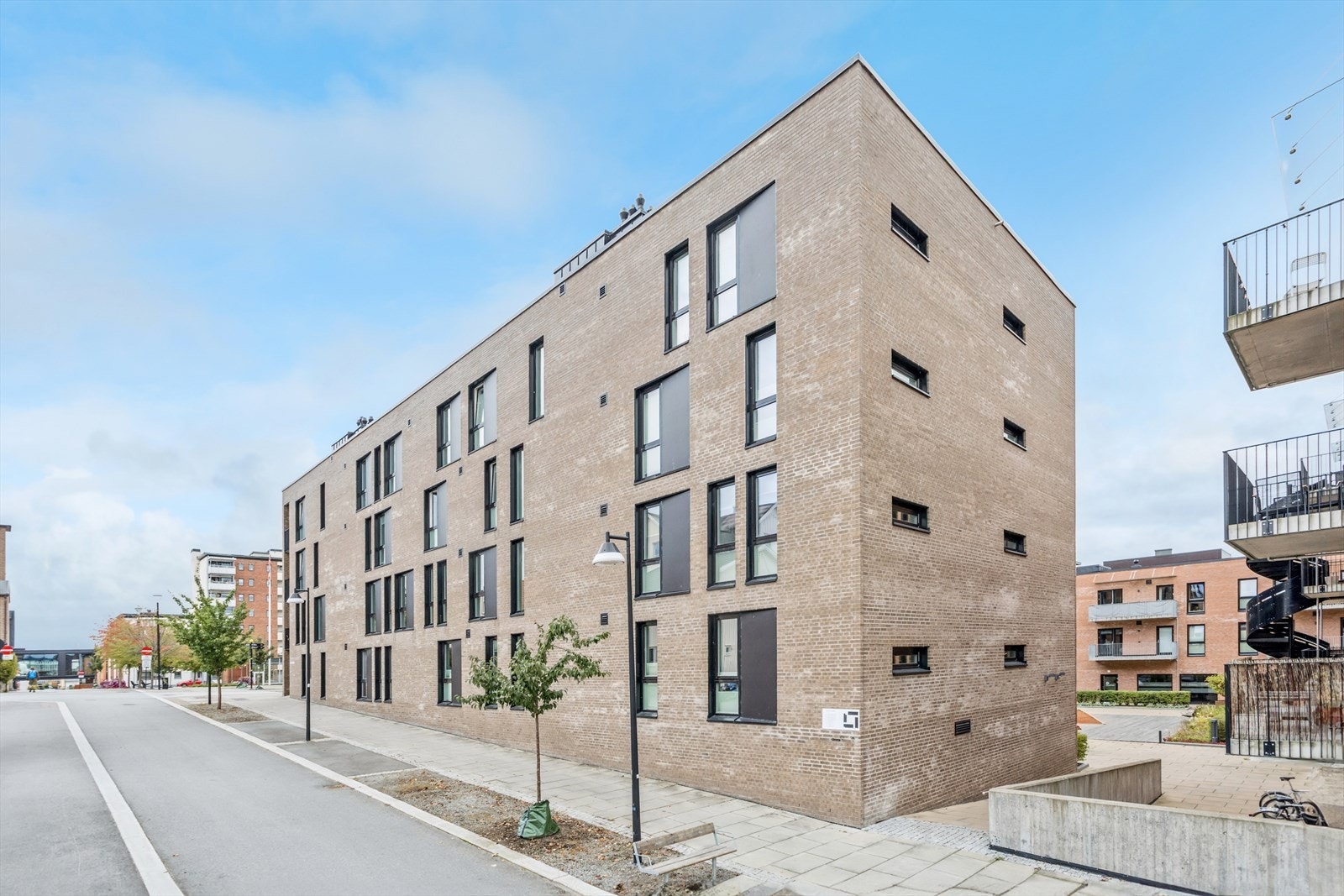 Bygget har en moderne arkitektur med teglsteinsfasade og store vindusflater. Galleribilde