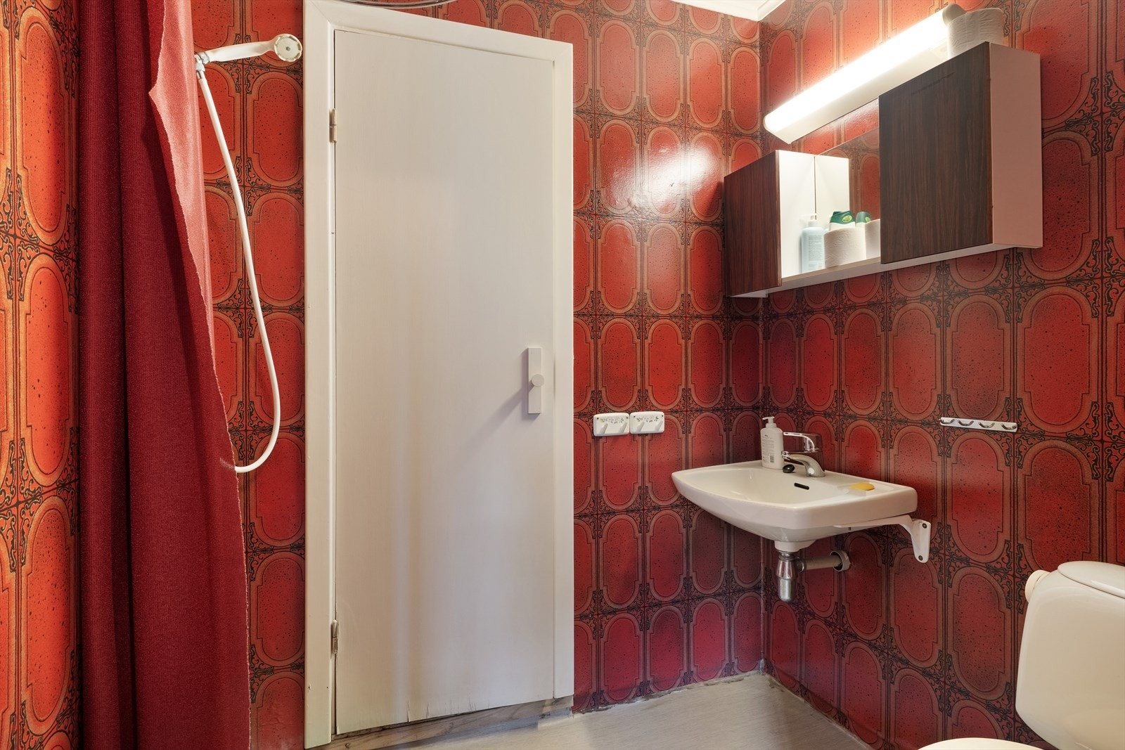 Baderom av enkel standard som har belegg på golv og tapet på veggar. Frå badet er det tilkomst til badstu med panelveggar. Galleribilde