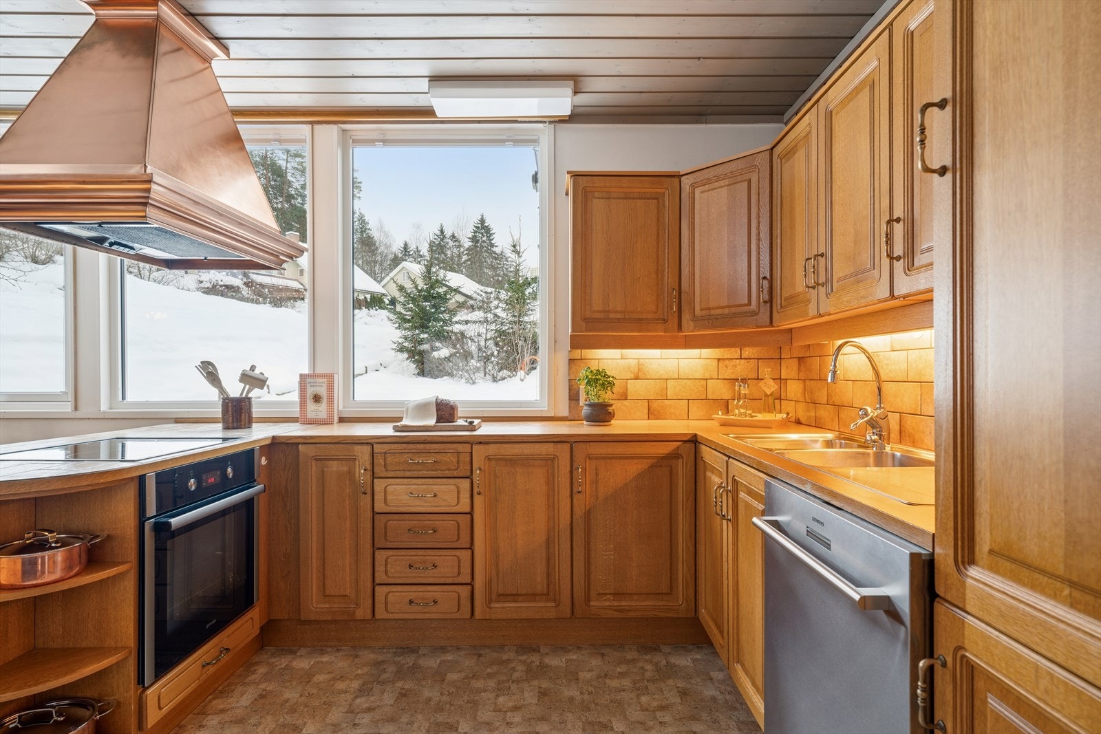 Husebykjøkken i tonet eik og med benkeplate av typen laminat. Galleribilde