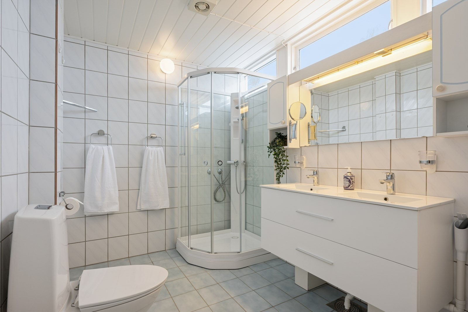 Opplegg for vaskemaskin og tørketrommel. Stilren og moderne baderomsinnredning med dobbel servant og gode skuffer for oppbevaring. Galleribilde