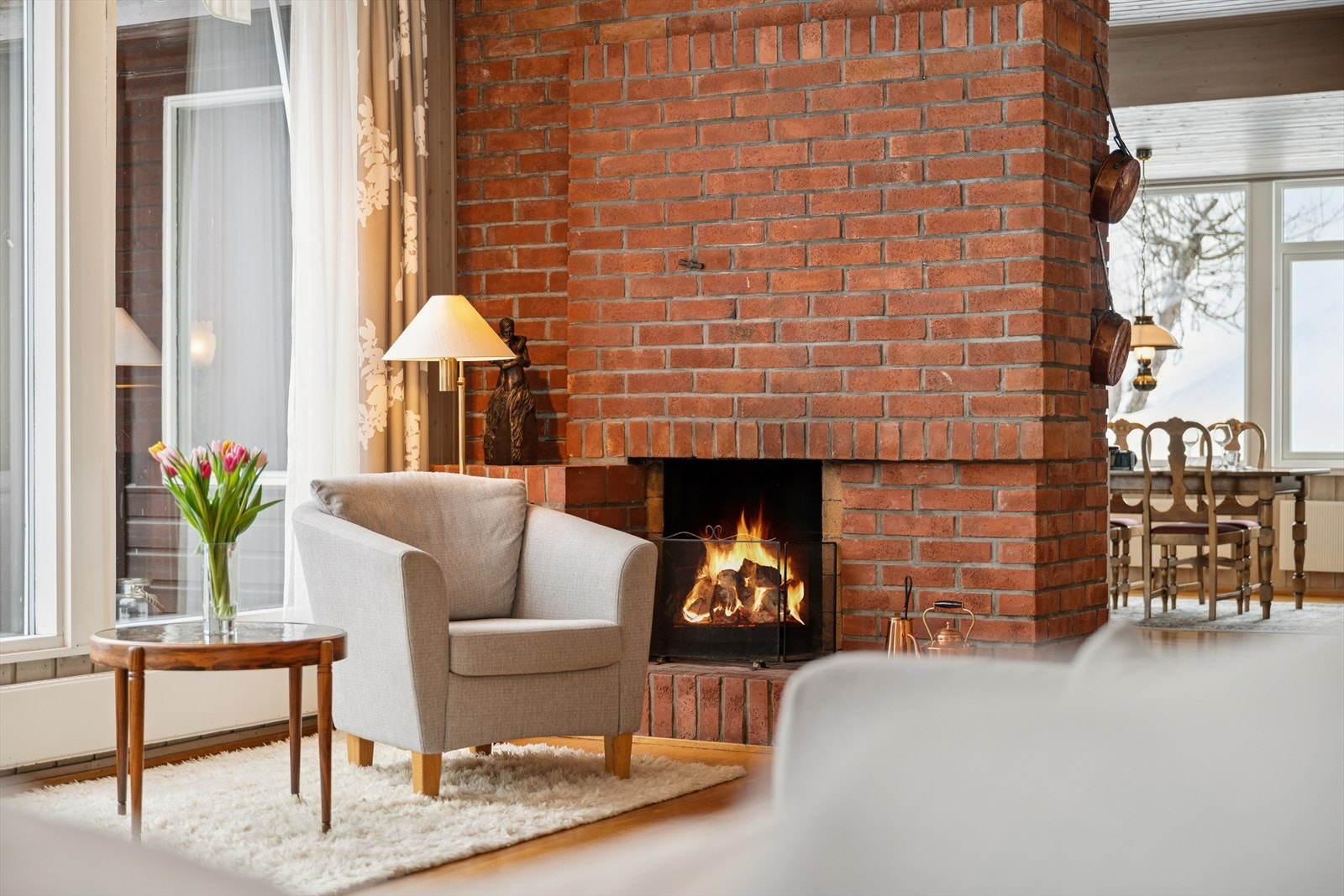Den åpne peisen er selve hjertet i rommet og bidrar til å varme opp både rom og stemning. Galleribilde