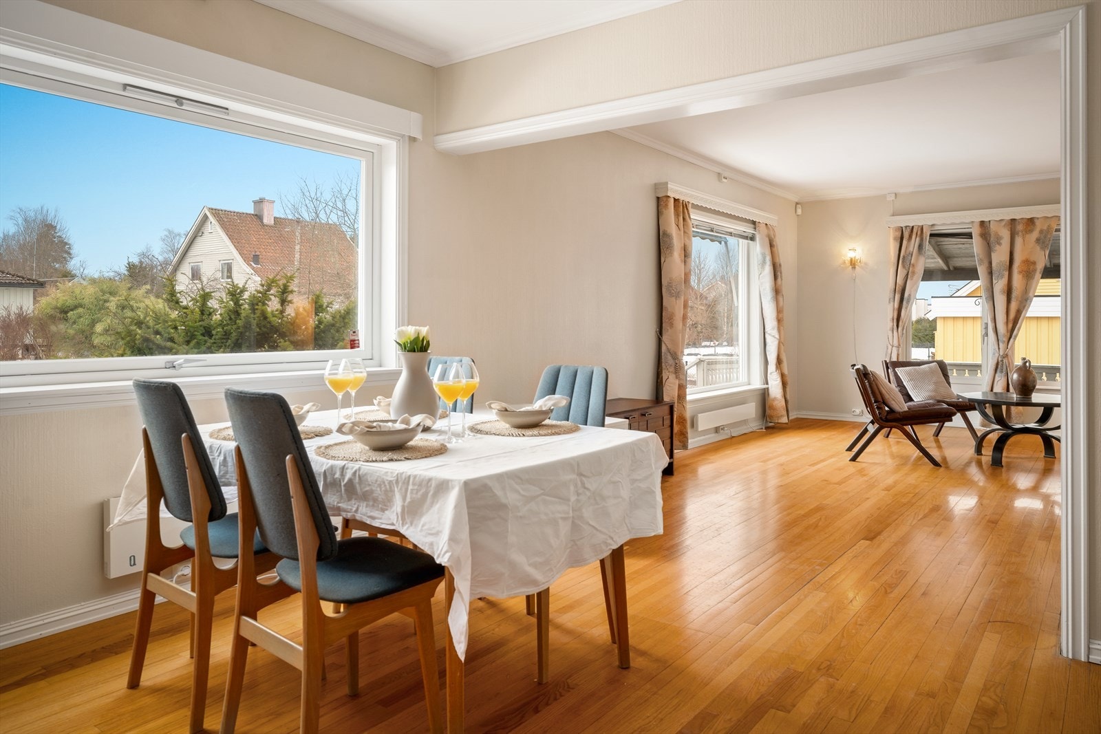 Stuen har store vindusflater med utsyn over en flat og stor hage Galleribilde