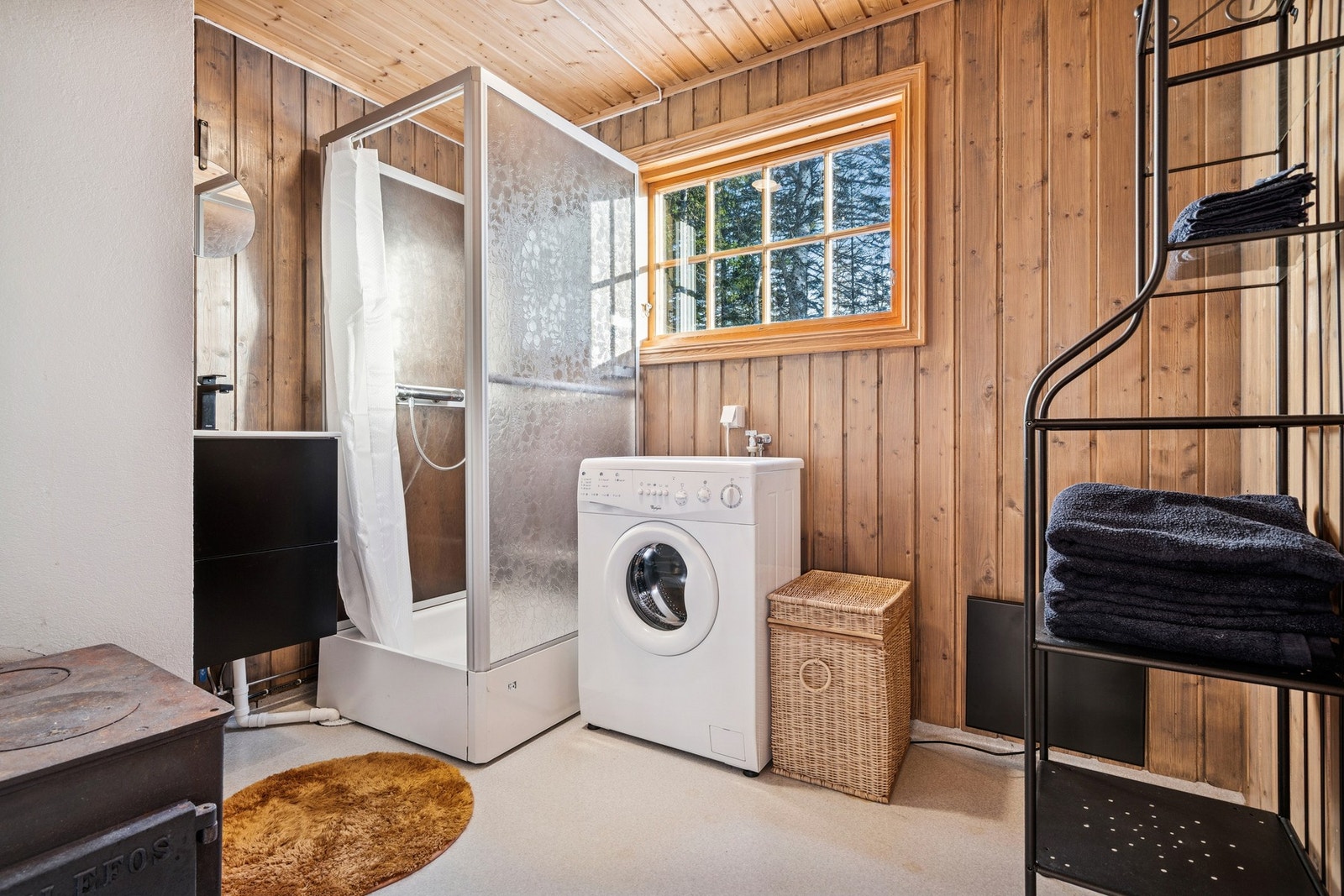 Badet har gulv belagt med belegg. Vegger med oppbrett og trepanel. Himling av trepanel og luke med loftstrapp. Galleribilde