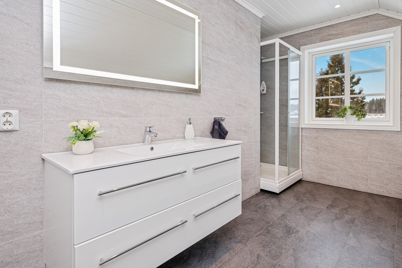 I hjørnet er det dusjkabinett. Vindu gir naturlig lys inn i rommet Galleribilde