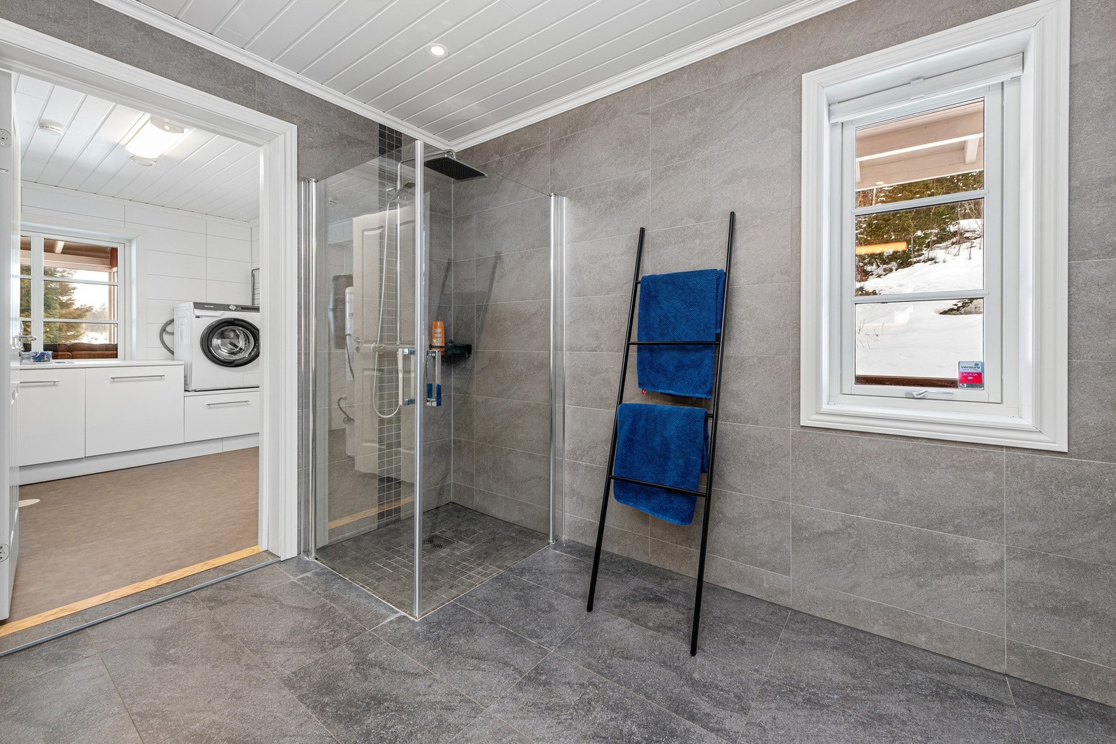 Dusjhjørne med glassvegger og veggehengt toalett. Spotlights i tak. Galleribilde