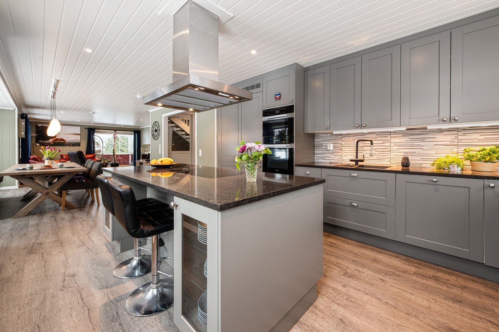 Stor platetopp på kjøkkenøyen med takhengt ventilator. Galleribilde