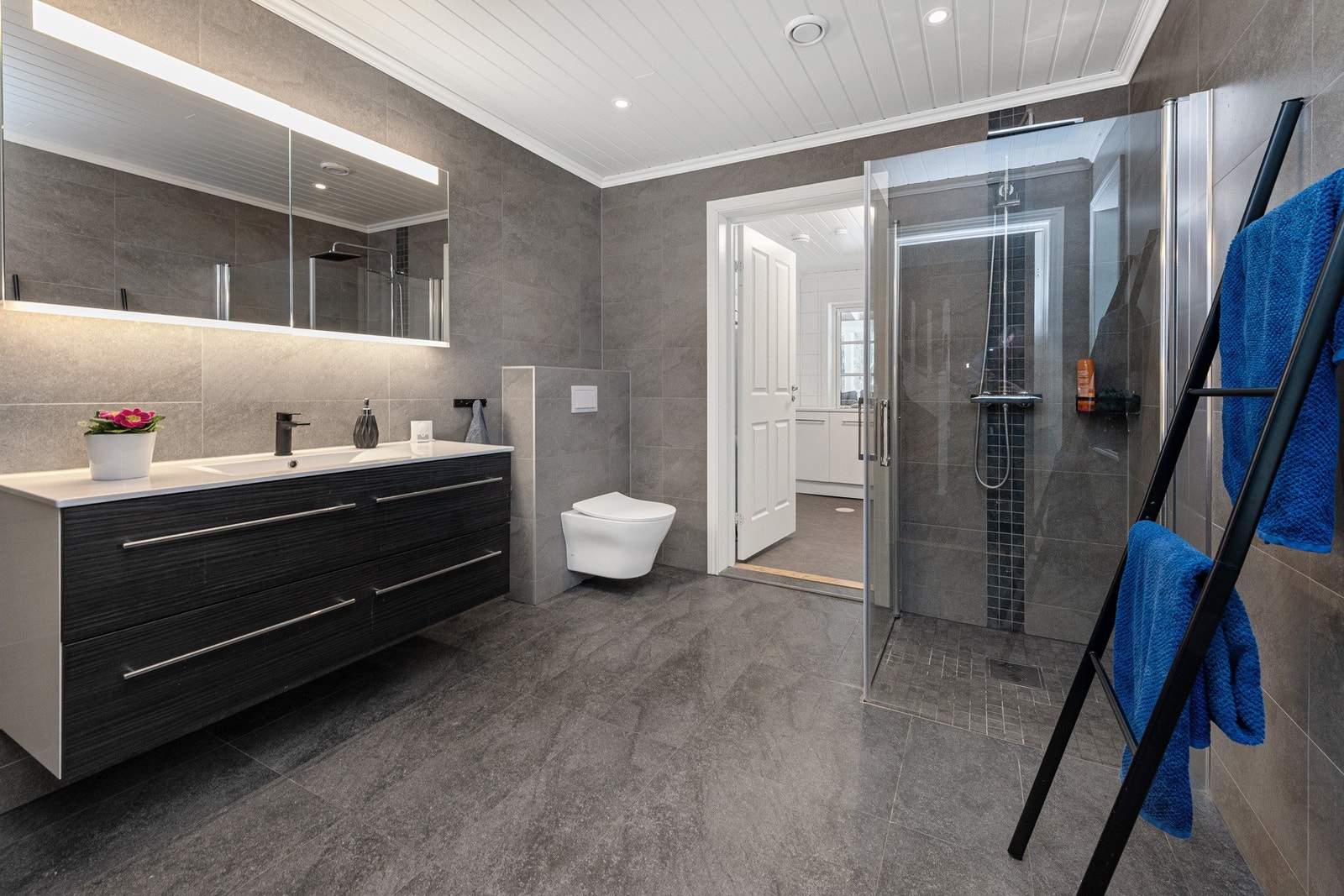 Stor bad i 1. etasje med fliser på gulv og vegger. Gulvbåren varme i gulv. Galleribilde