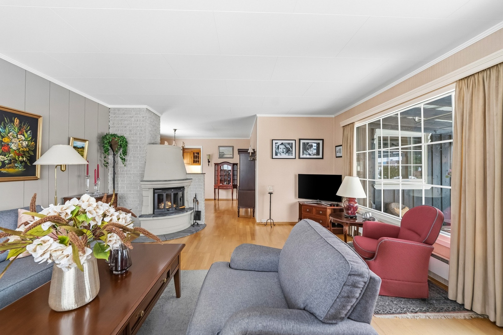 En oppmurt peis er plassert sentralt i rommet og bidrar både med varme og en lun atmosfære. Øvrig oppvarming skjer via elektriske panelovner. Galleribilde