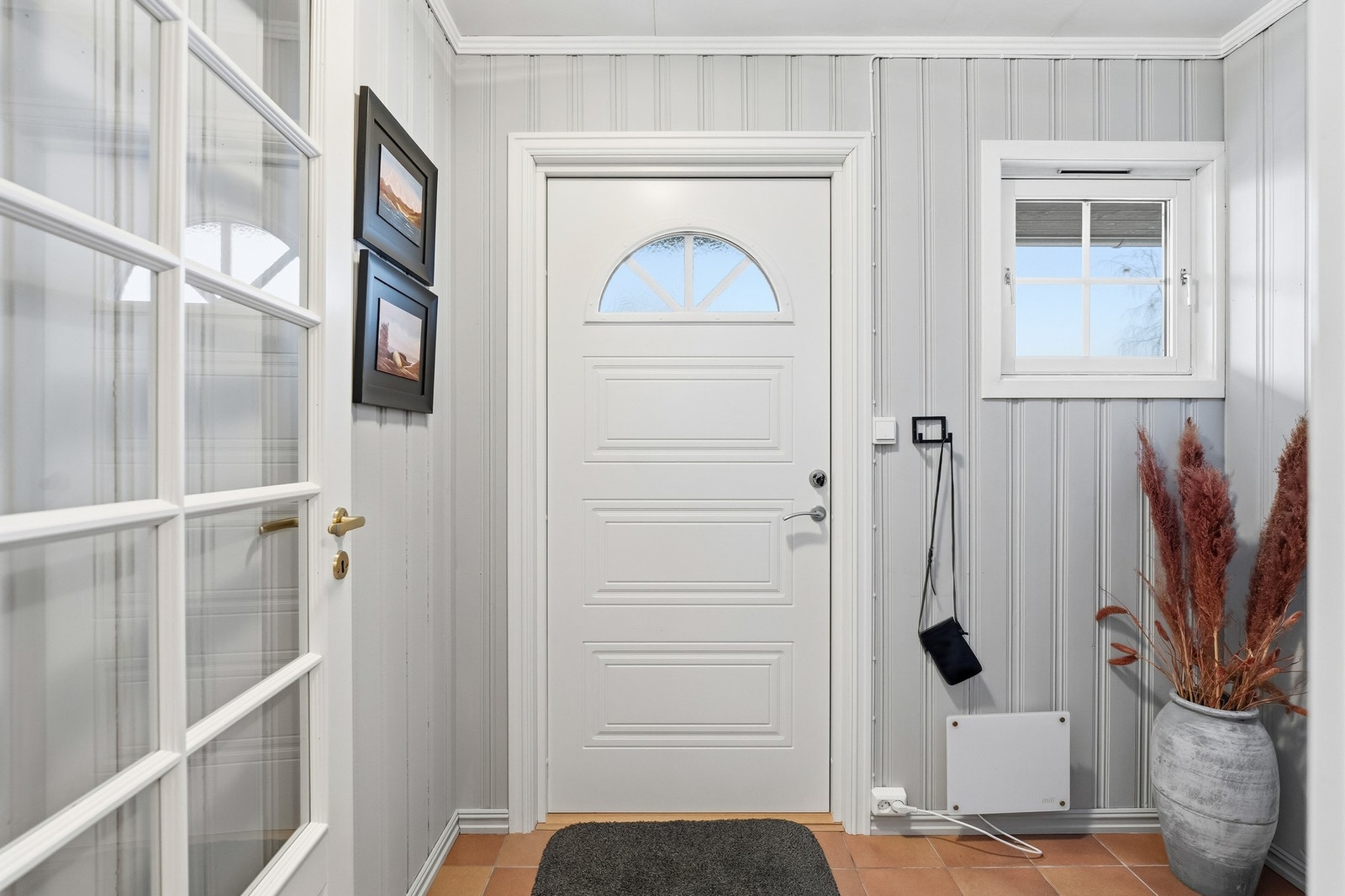 Et hyggelig, flislagt inngangsparti ønsker deg velkommen inn i boligen. Galleribilde