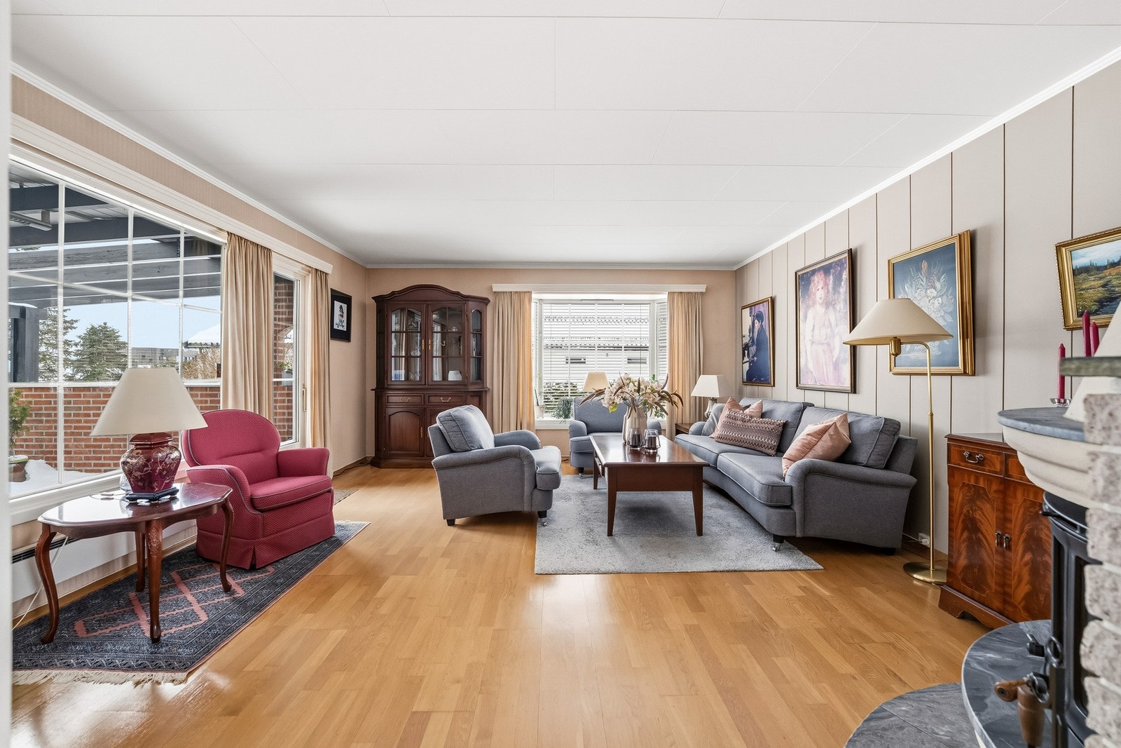 Stuen fremstår som lys og romslig med tapetserte veggflater i kombinasjon med malte plater. Galleribilde