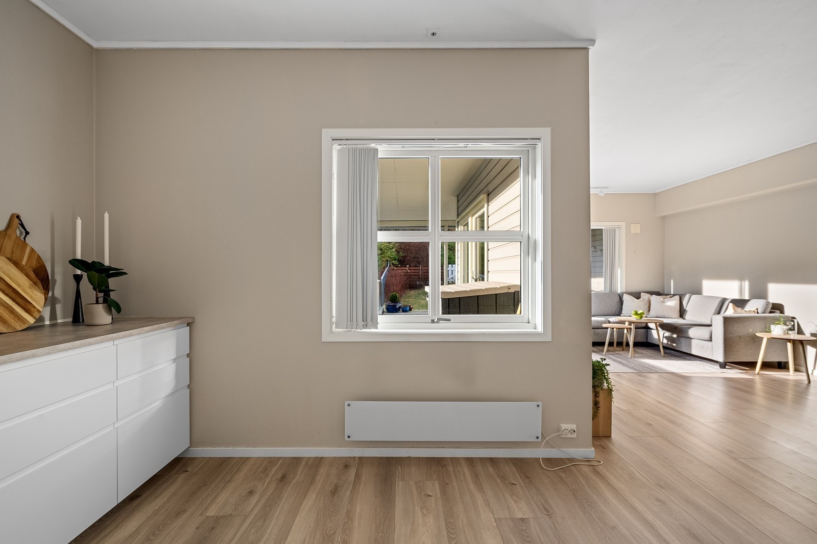 Tilbaketrukket kjøkkenrom med vindu ut mot terrasse. Galleribilde