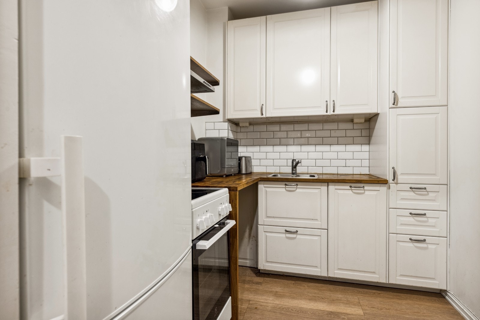 Kjøkken med kombiskap, komfyr og oppvaskmaskin Galleribilde