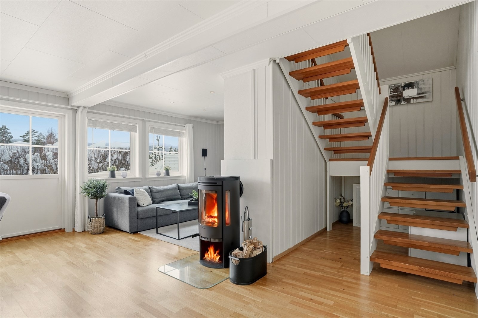 Peis er sentralt plassert i rommet. Boligen har også installert varmepumpe over vegg hvor det i dag står spisebord
. Galleribilde