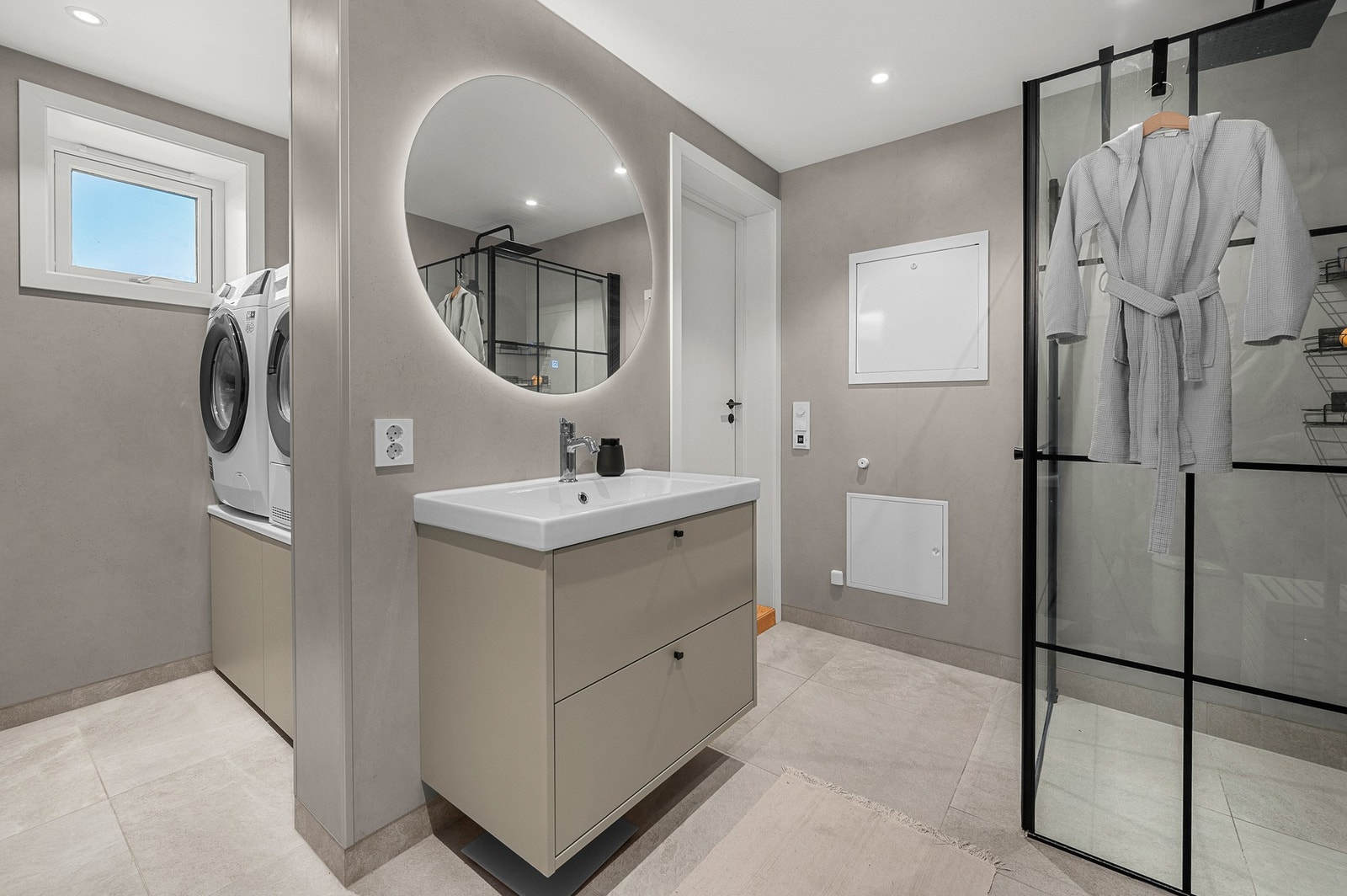 Det er en baderomsdel med dusj, servant og toalett, og en vaskeromsdel med egen nisje for vaskemaskin og tørketrommel, i tillegg til oppbevaring. Galleribilde