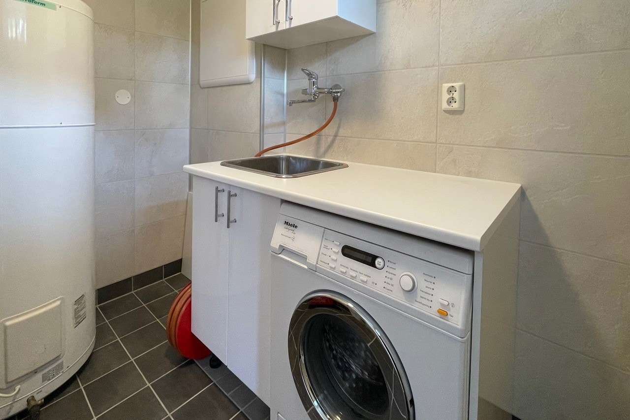 Helfiset vaskerom med adkomst til entrè - Inneholder servant og vaskemaskin. Galleribilde