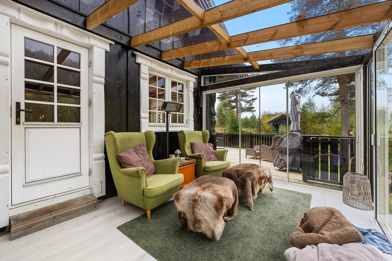 Her kan man sitte lunt og godt for vær og vind. Ved å åpne skyvedørene har man tilgang til terrasse og uteområdet ellers. Galleribilde