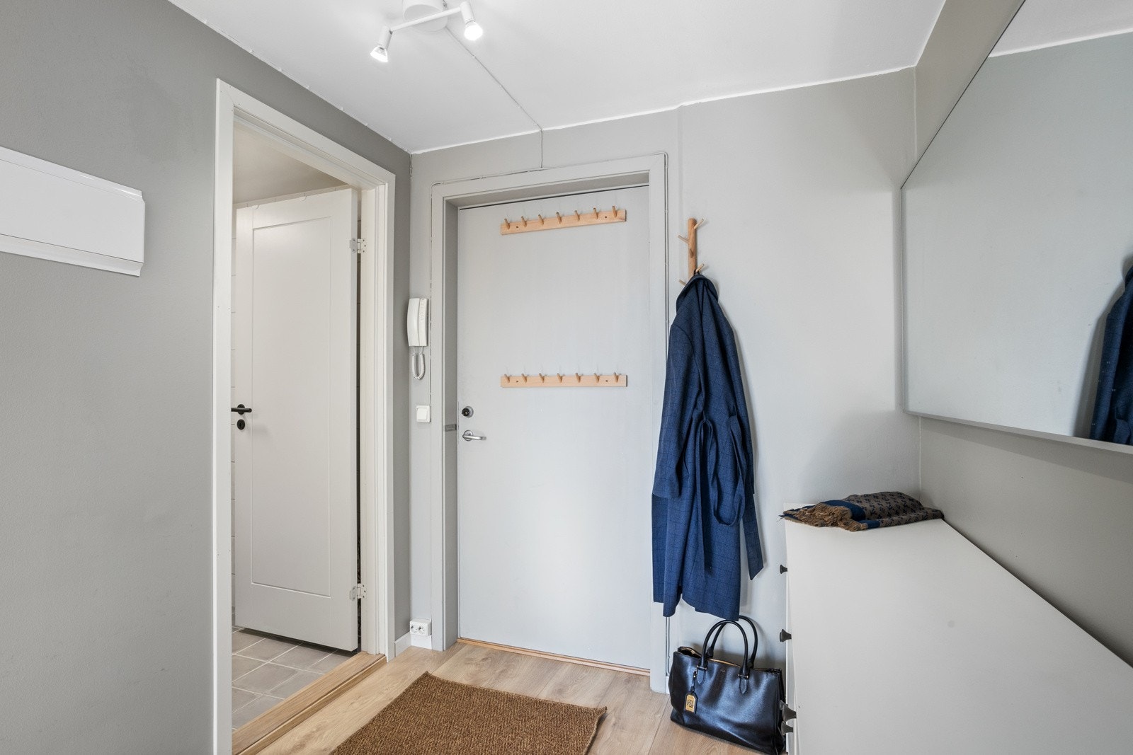 Lys og trivelig entré med inngang til baderommet Galleribilde