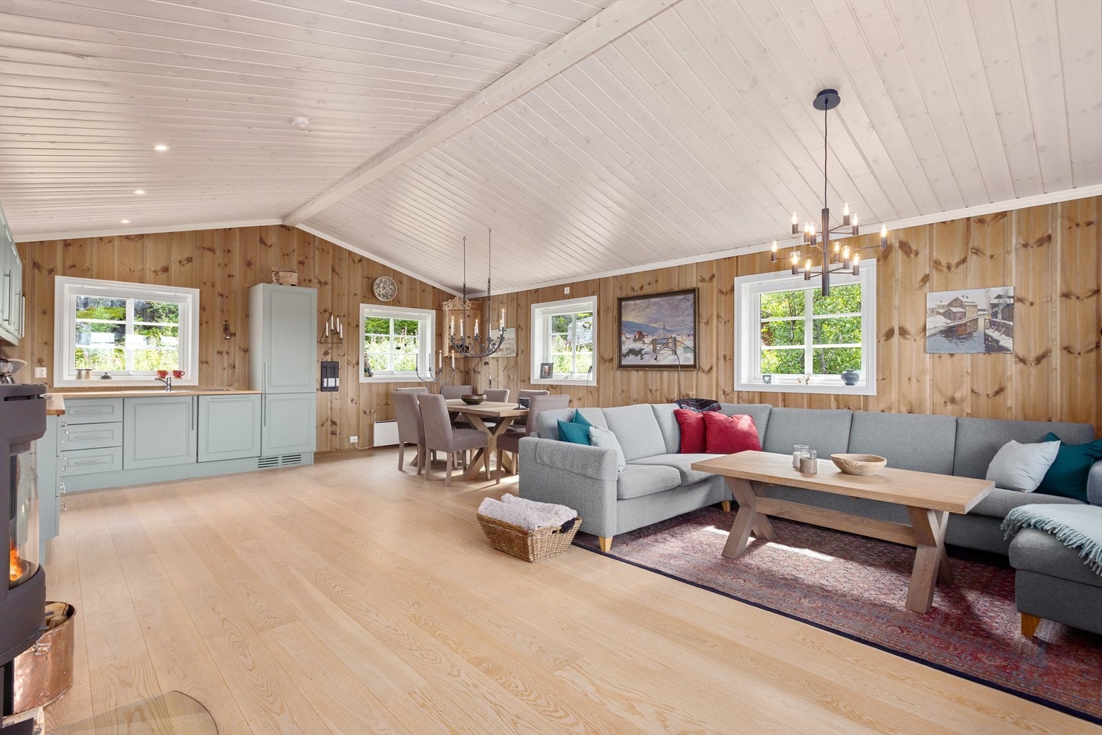 Den åpne stue- og kjøkkenløsningen skaper et sosialt og innbydende allrom, perfekt for hyggelige sammenkomster med familie og venner. Galleribilde