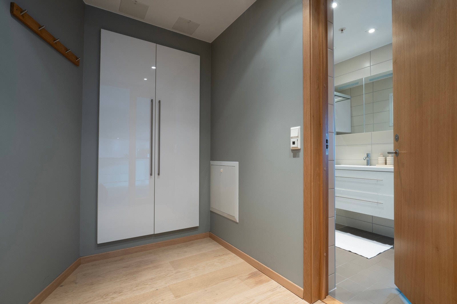 Romslig entré/gang med dobbel glassdør mot stuen. God plass til oppbevaring av yttertøy i plassbygget garderobeskap fra Crown Imperial. Galleribilde