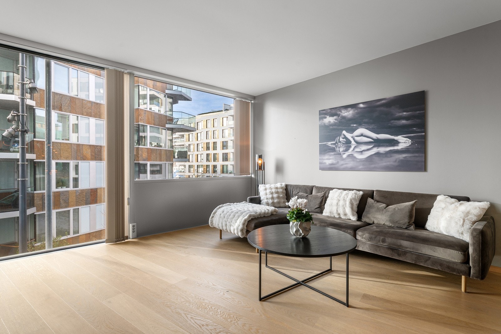 Stor stue med åpen kjøkkenløsning, store vindusflater og god plass til spisestue og sittegruppe. Rommet er på over 40 m² og innbyr til sosiale sammenkomster Galleribilde