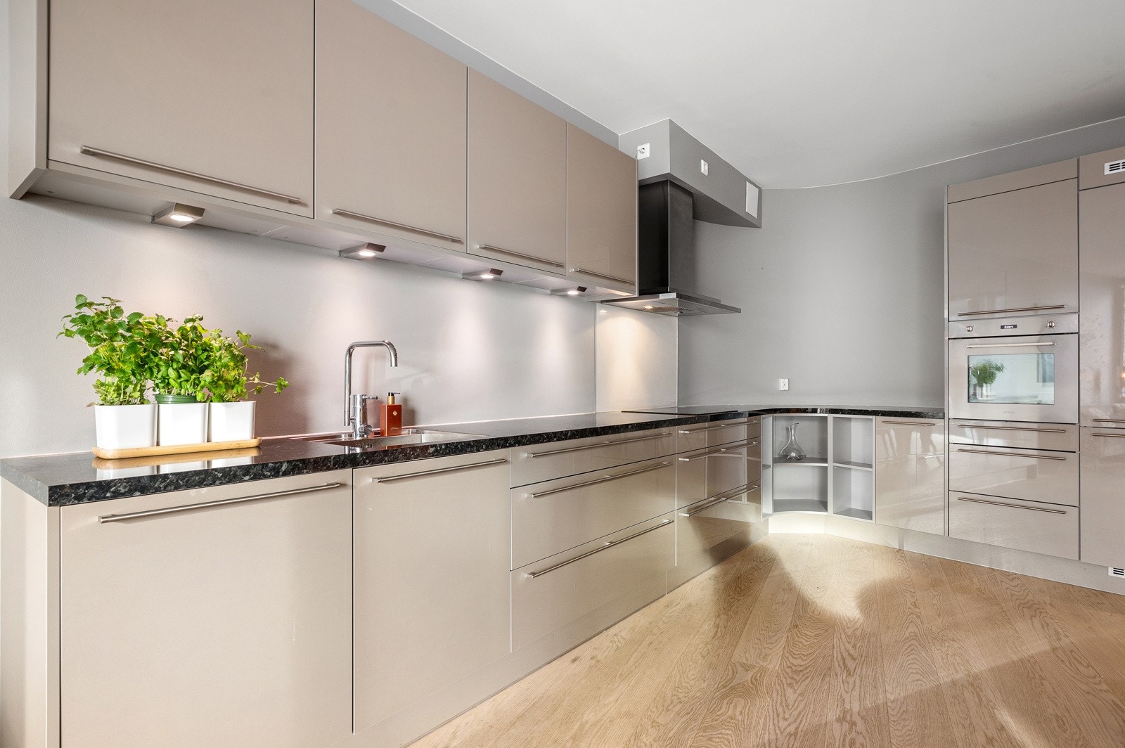 Delikat kjøkkeninnredning fra Crown Imperial med integrerte hvitevarer fra Smeg. Kombi kjøl- og fryseskap, oppvaskmaskin, stekeovn, induksjonstopp og ventilator med avtrekk. Galleribilde