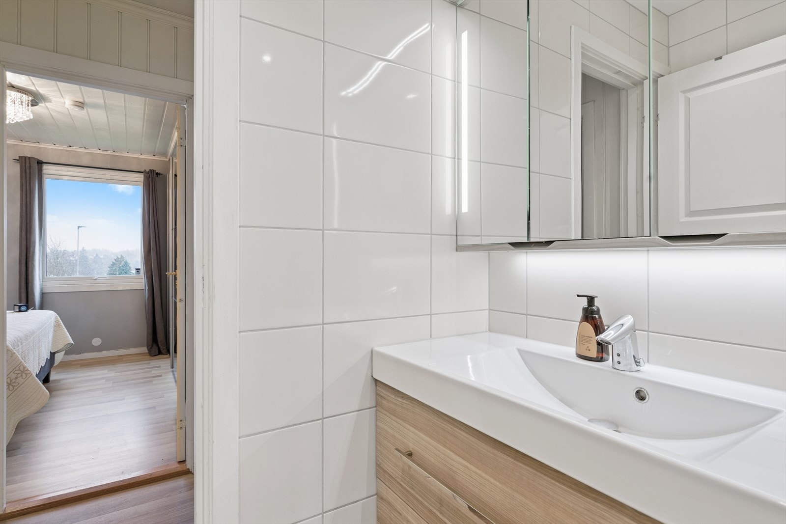 Benk med heldekkende porselensvask, overskap m/speil dører med innebygget lys. Galleribilde