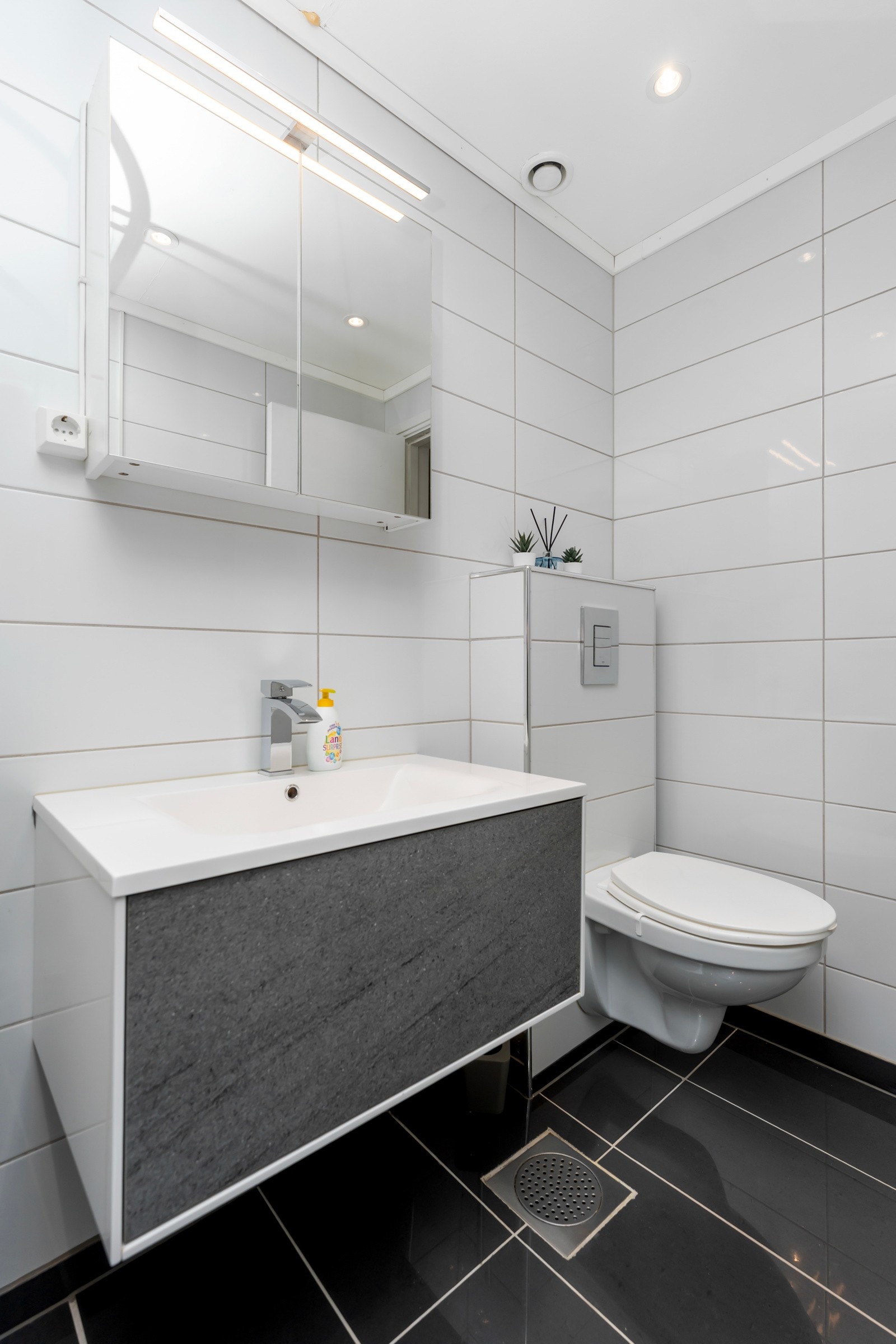 Badet har spotter i tak, vegghengt toalett og pen innredning. Galleribilde