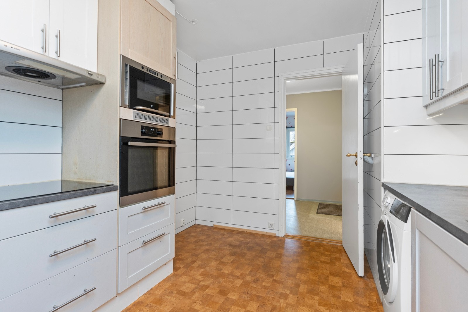 Kjøkkenet er lyst med integrerte hvitevarer. Galleribilde