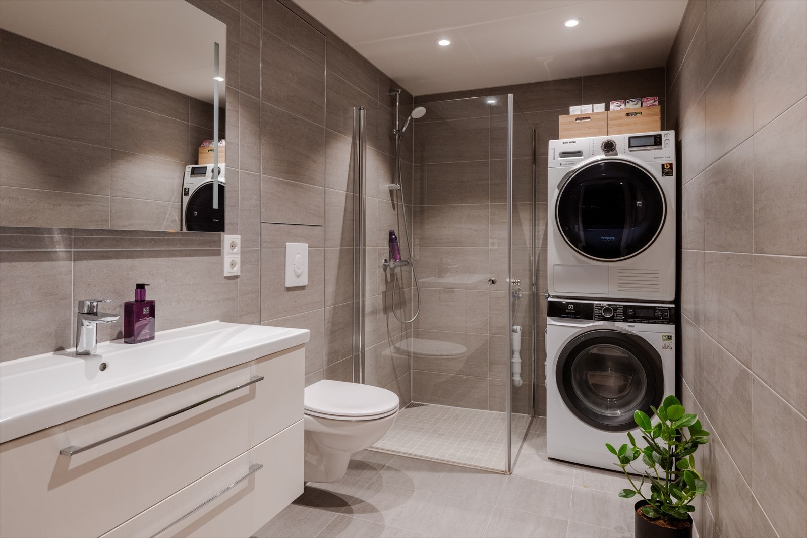 Lekkert, flislagt baderom med varme i gulvet og opplegg for vaskesøyle. Galleribilde